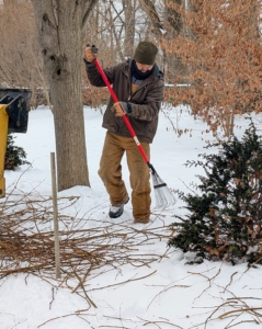 Chhiring stays on the ground raking up the fallen branches and watching everyone from below.