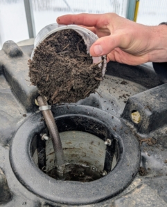 Ryan fills the filter basket with nutrient rich compost.