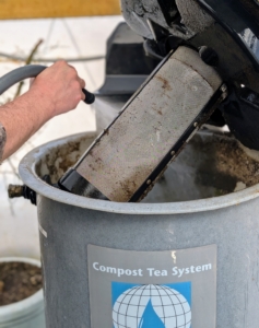 Here, Ryan rinses the filter to remove any residual compost.