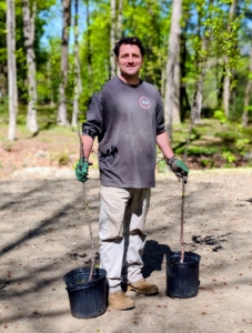 Ryan positions the trees first, followed by the azaleas and then the smallest plants by the pond's edge.