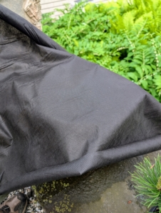 Landscape fabric is made from a solid sheet with perforated holes to allow water to soak through. It is available at any garden shop.