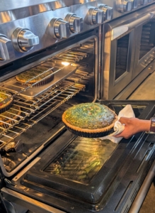 By mid-morning, cooking is already underway in my outdoor kitchen and flower room. Here is one of three spinach pies coming out of the oven.