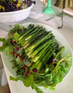 The green asparagus is dressed with radishes and radish greens.