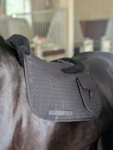 Now to get Bond ready for a ride. This is the saddle pad, which cushions the horse's back under the saddle and protects it from the weight of the rider. This pad is from Mattes and has built in pockets for a cell phone and treats.