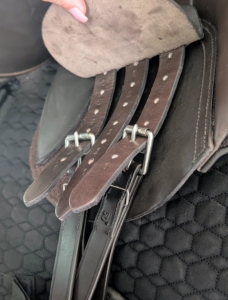 The girth strap is secured with these leather strips called billets.