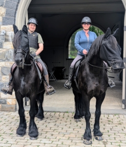 Here's Juan on Geert and Helen on Bond. The fly masks keep the pesky bugs from biting. A well-fitting saddle gives the horse freedom of movement without any discomfort. It also helps the rider sit correctly.