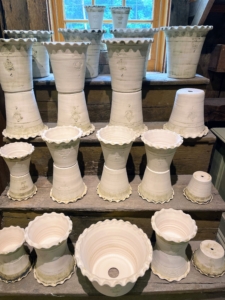 On another side – dozens of beautiful white clay vessels with decorative edges.