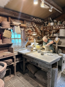 Through a small doorway is the additional room where all the pots are created. Look closely – the corner wall behind the potter’s wheel is filled with small tools called coggles, roulettes, or rolling stamps, which are used to decorate the pottery.