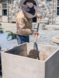 Then Pete fills about a third of the pot with composted soil. This nutrient-rich compost is made right here at the farm.