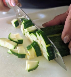 Two small zucchinis are provided for this recipe. Cut them both into quarter-inch pieces.