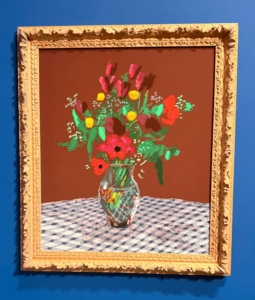 In the larger display of this large-scale photographic drawing, "Looking at the Flowers," 2022, it shows David sitting at both left and right sides, sitting in a chair, looking at the wall of smaller framed works.