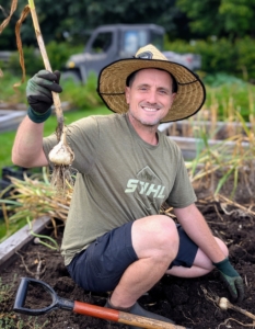 Here's Ryan with one of the first garlic heads of the season.
