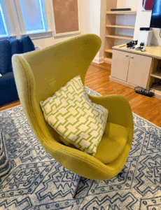Here's a playful pop of style for those interested in a fun chartreuse egg chair with a modern geometric pillow.
