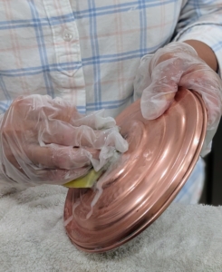 Here is a lid also being carefully rubbed with Wright's Copper Cream.