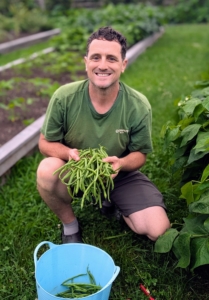 Ryan picks a few handfuls of beans, but there are still so many growing on the vines. They can continually produce throughout the season with the proper care. In general, bush beans are ready in about 45 to 50 days if the weather is right.