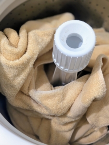 In this load, Elvira places a number of bath towels into the sizable tub, spreading them equally around the machine's agitator.