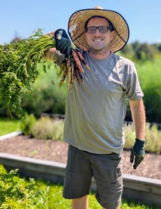 Here's Ryan with a bunch of beautiful carrots. Most are familiar with the orange color, but they also come in red, yellow, white and purple.