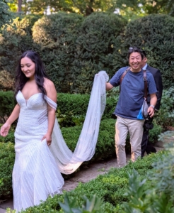 When selecting a photographer for a special occasion, be sure to look at his or her portfolio to ensure their style of photography matches the desired vision of the shoot. It's also important that the photographer's personality is compatible. The session should be fun for all. Here, Don carries the bride's long cathedral veil along the footpath of my Summer House Garden.