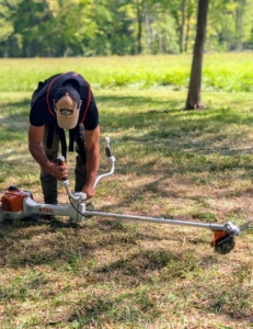 Adan Morales, who works on my outdoor grounds crew and handles all the lawn and brush cutting equipment sets it up to test and cut some of the unwanted growth in my hayfield.