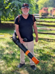These blowers are used all year round. Fernando secures the three-point harness which makes it easy to carry and operate.