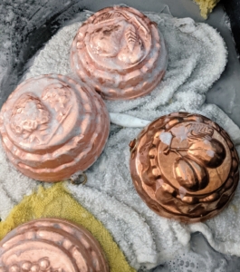 But here, one can see the differences between the polished molds and the one still left to do. Notice the ones on the left are in the final soap and rinse stage – so shiny, while the darker piece on the right is waiting its turn.