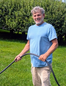 Fernando holds one end in place as Pete positions the hose under and around the plants.