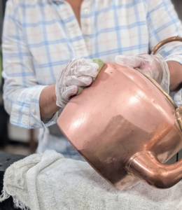 Using gloves to prevent the cleaning cream from coming into contact with the skin, completely coat the piece. The copper will start to brighten as it is rubbed. This task is time-consuming, but it is well-worth all the work and elbow grease. And remember to get into all the cracks and crevices.