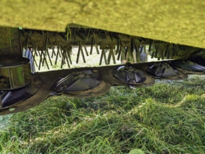 The discs and blades are located behind the protective shield of the mower-conditioner.