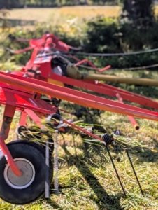 The tines are connected to these rotors, which are the moving parts of the tedder that lift and spread the hay.