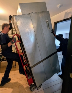This team works methodically and carefully. This old unit is wheeled out without touching a thing.