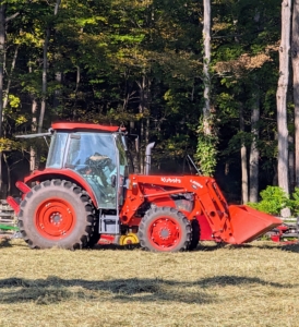 Here's Fernando on my trusted Kubota M4-071 tractor – a vehicle that is used every day here at the farm to do a multitude of tasks. The hay was cut and tossed for drying two days prior. Now it's time to bale.