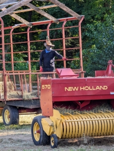 Here is Cesar in the hay wagon behind the baler ready to accept the bales and stack them.