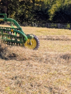 The bar rake is hydraulically driven. This rake allows for consistent movement across the fields making well-shaped windrows. The rake moves at a slight angle to create the windrow. A windrow is a long line of raked hay.