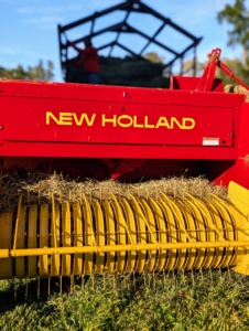 A baler is a piece of farm machinery used to compress a cut and raked crop into compact bales that are easy to handle, transport, and store.