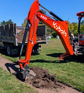 At each carefully measured spot, Chhiring uses the backhoe to remove the soil.