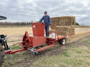This is a mulching machine. The bales of straw are put through the grinder and then dropped over the soil. This will protect the garlic during the cold Wisconsin winter.