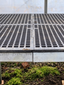 These industrial strength rubber topped tables can hold heavy containers without damaging them. They also have holes to allow water to drain easily.