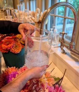 Then she carefully pours water into the vase as quickly as possible. Fill the vase to about three-fourths of its height. This amount allows the flowers to absorb enough water to stay healthy and vibrant. And be sure to keep it filled and change the water regularly.