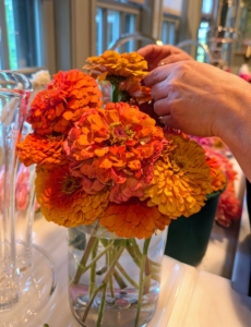 For this arrangement, Enma chooses shades of orange and gold zinnias. Zinnias are native to Mexico and Central America. The Aztecs originally called them “plants that are hard on the eyes” because of their colorful flowers. Zinnia is named after Johann Gottfried Zinn, a German botany professor who discovered the plants and brought them to Europe in the 1700s.