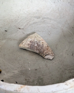 The shards help with drainage and to keep the soil from leaking out of the vessel.