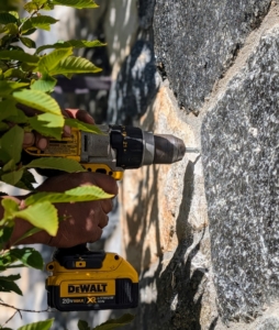 Pete applies some pressure to ensure the drill goes in straight - the mortar can be a little tough.