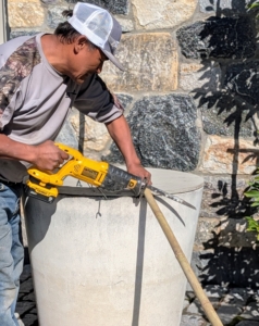 Using a portable saw, Pete cuts the bamboo to size. Bamboo stakes can be found in a variety of sizes at garden shops or garden departments of big box stores.