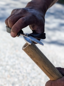 After cutting, Pete trims off any bamboo splinters from the cut end of the bamboo.