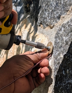 Then he carefully secures the screw into the hole.
