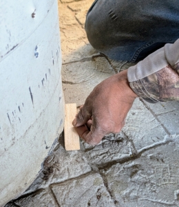 Next, Pete adds wood shims under all the pots to keep them balanced on the stable floor. These pots have side holes for draining; however, if a pot's hole is at the bottom, raising it on shims will allow the water to drain better.