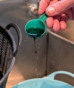 First, he pours one tablespoon of each concentrate into a trug bucket of cold water.