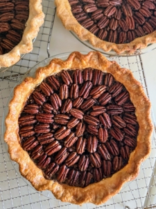 And a traditional pecan pie. The team works in an assembly line fashion to get all the pies ready on time. Once cooked, they are left to cool – on the counter, on the stovetop, near the sink – anywhere there is room.