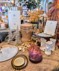 On one table are items I personally selected - Martha's Must Haves for the holidays. They include the Tree of Life Menorah, the Aged Iron Cluster Taper Candle Holder Dish, Golden Tinsel, a Twinkling Vine Bell, an Ivory Ceramic Faux Bois Vase, a Leafy Rattan Hinged Tree Collar, a Habit Form Tray, 15-inch Silver Beaded Trees - all available at Terrain.