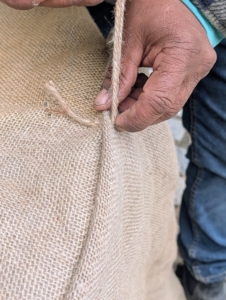 To sew the burlap, the crew uses jute twine. It is all natural and the same color as the burlap.