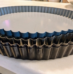 While I roll out the doughs, Enma gathers all the necessary tart pans and pie plates.